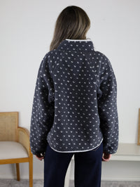 Back view of the Reba Fleece Puffer Jacket in dark gray high-pile fleece with a white heart pattern and a high collar.