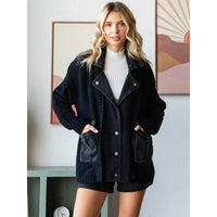 A woman with long blonde hair wears the Veveret - Knit Body Denim Layerd Jacket: Cream / Denim / L over a white top and black shorts, standing indoors by a table and abstract wall art.