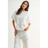 White eyelet embroidered cotton blouse on model