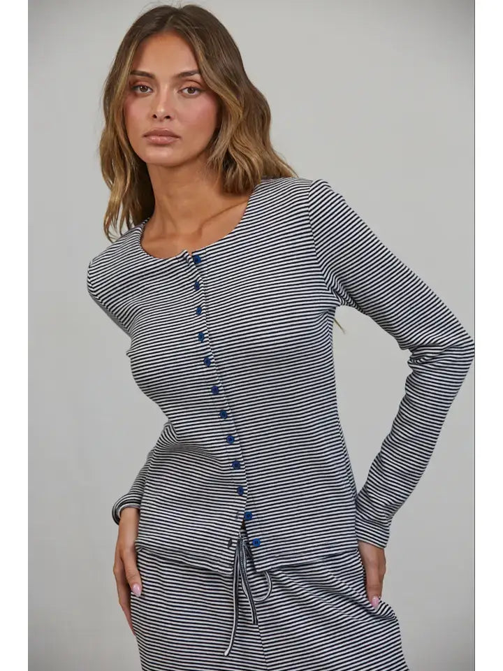 A woman with long brown hair wears the Creamon - CTP3592 BROWN Lounge Striped Button Down Top & Pants Set in Brown Stripe, featuring a long-sleeve button down top with blue buttons and a drawstring waist, paired with matching wide leg pants, as she stands against a plain background.