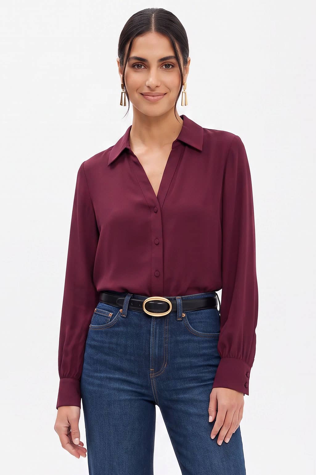 A woman wearing a Naked Zebra - Neck Shirt With Open Seam Sleeve: Wine / L paired with dark blue jeans and a black belt.