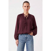 Chocolate Naked Zebra - Billowy Tie Neck Long Sleeve Blouse with a billowy fit, tie-neck, button-front placket, and cinched hem, worn with blue jeans.
