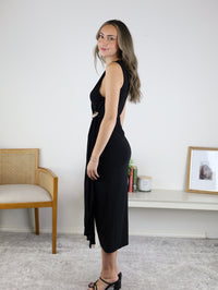 A woman in profile wears a black Kamden Side Gather Midi Dress, featuring a V-neck, side gathering, and a decorative waist accent.
