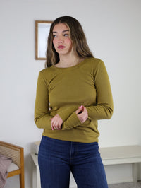 Woman wearing a long-sleeved olive green Dee Ribbed Round Neck Tee and dark blue jeans.