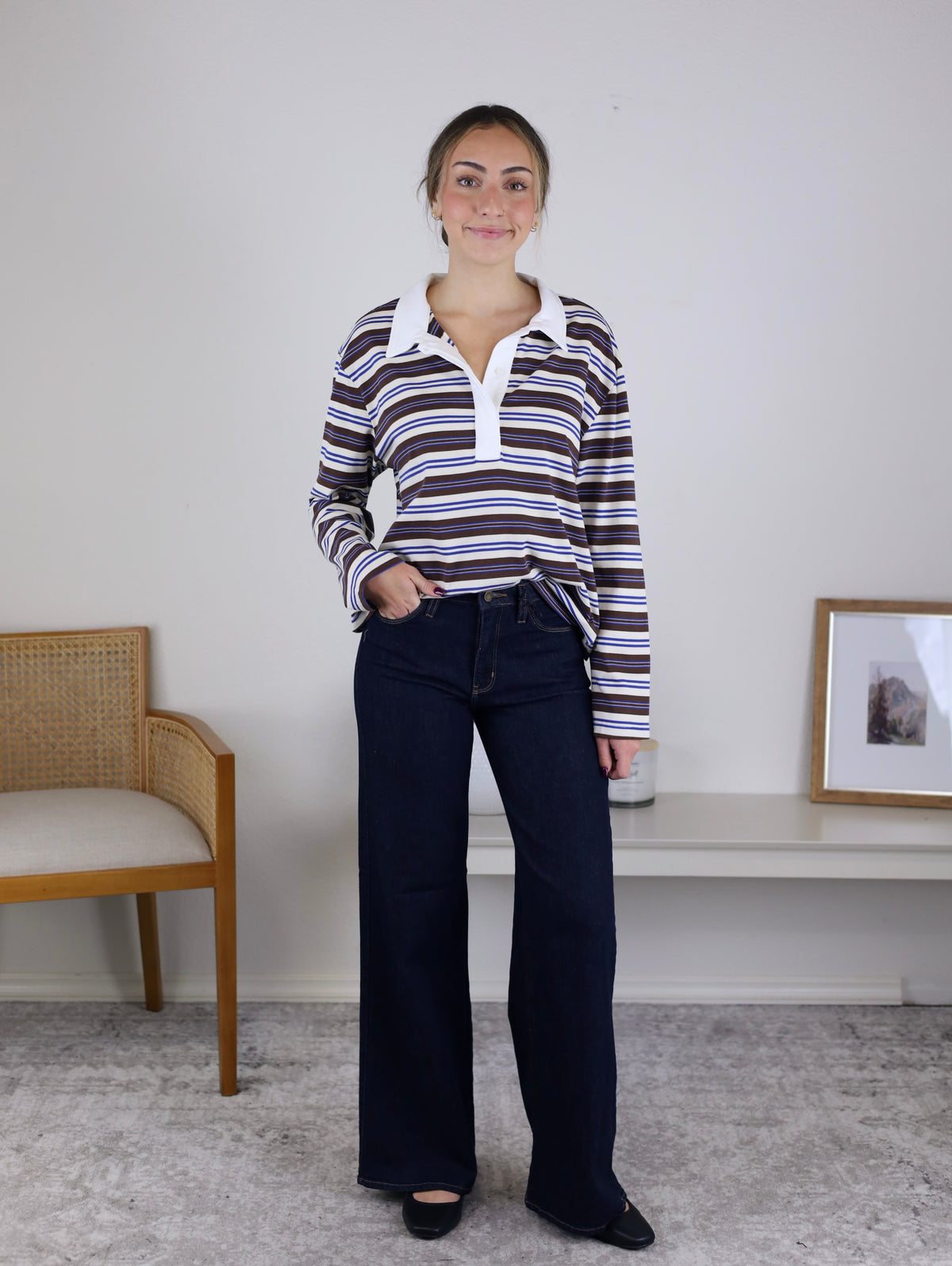 A woman wearing a Striped Rugby Top with Contrast Collar paired with dark blue wide-leg jeans.