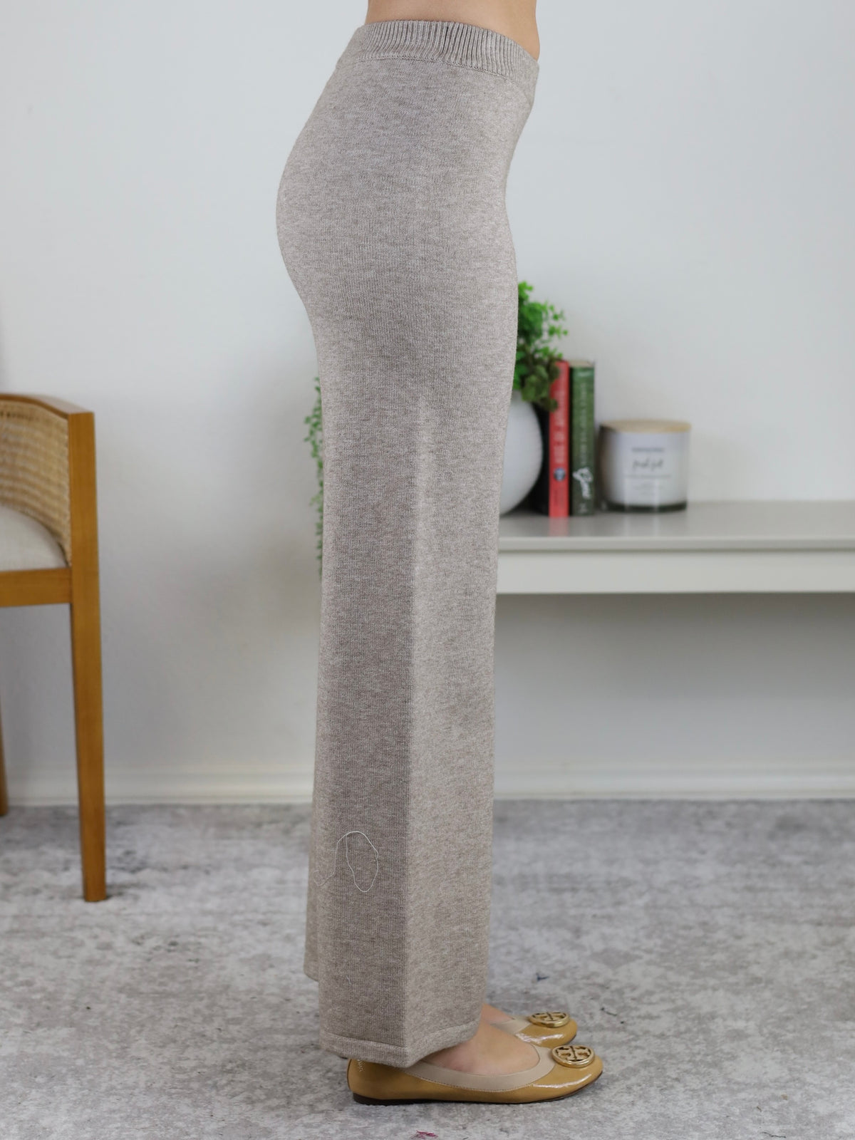 Side profile of a person wearing a beige Rebecca Sweater/Pant Set featuring knit high-waisted wide-leg pants paired with tan ballet flats.