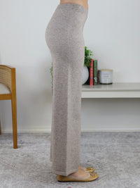 Side profile of a person wearing a beige Rebecca Sweater/Pant Set featuring knit high-waisted wide-leg pants paired with tan ballet flats.