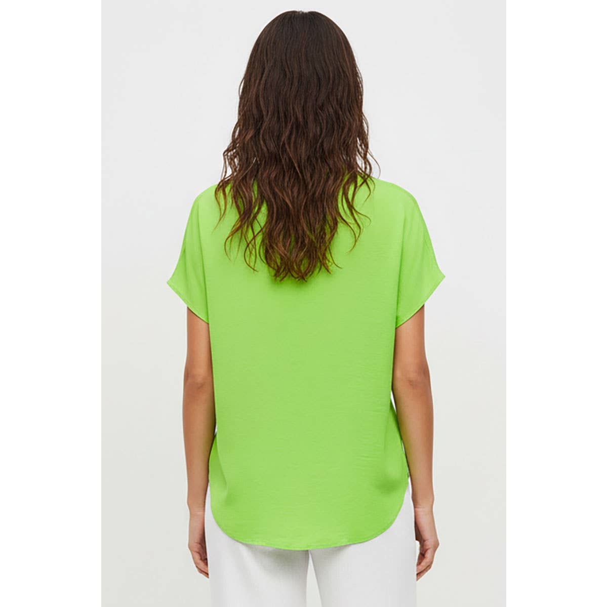 A woman seen from the back wearing a bright lime green Naked Zebra - Drop Shoulder Regular Blouse: Chocolate / L.