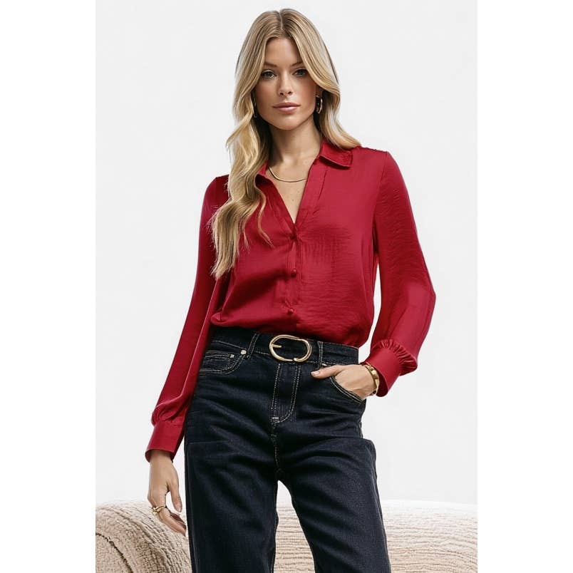 A woman wearing a red Naked Zebra - Neck Shirt With Open Seam Sleeve: Black / L tucked into dark blue jeans with a black belt.