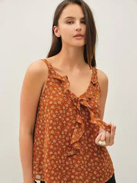 Woman wearing Paige orange floral ruffle tank with a ruffled V-neck and chiffon drape