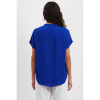 Back view of a person wearing a bright blue, short-sleeved, drop-shoulder Naked Zebra - Drop Shoulder Regular Blouse: Chocolate / L with a curved hem.