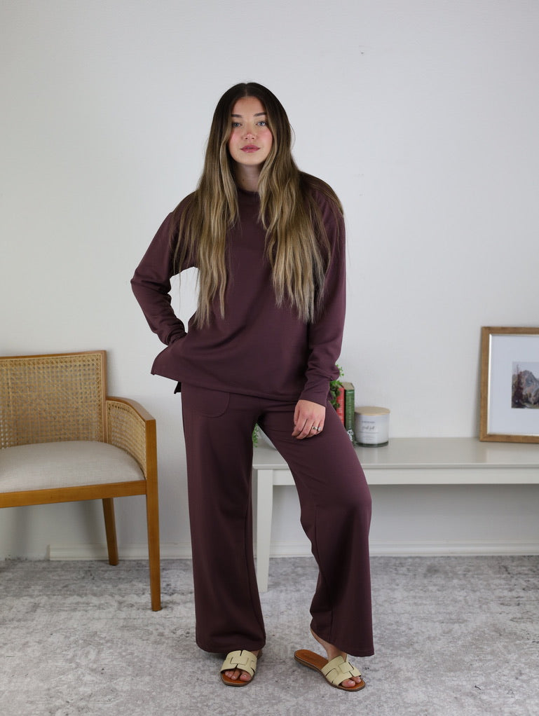 A woman wearing a dark purple long-sleeved shirt and matching Adaline Wide Leg Sweatpants.