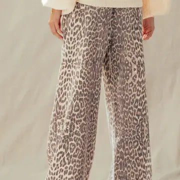 Close-up of leopard print wide-leg pants elastic waistband with cream drawstring tie
