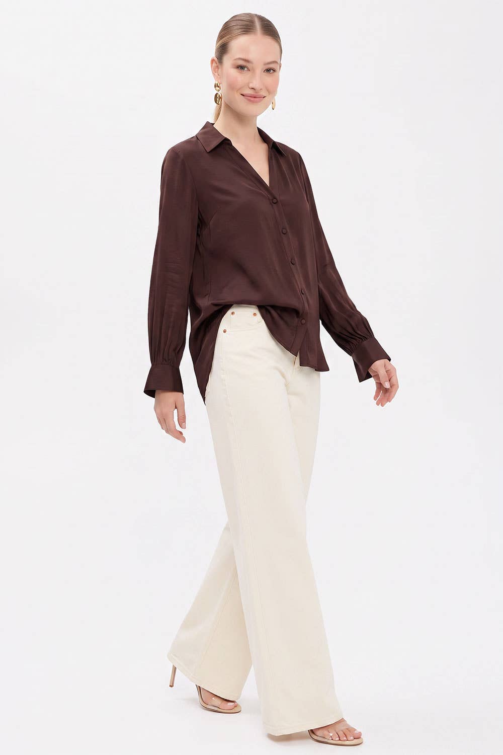 A person wears a wine-colored Naked Zebra - Neck Shirt With Open Seam Sleeve tucked into wide-leg cream-colored trousers.
