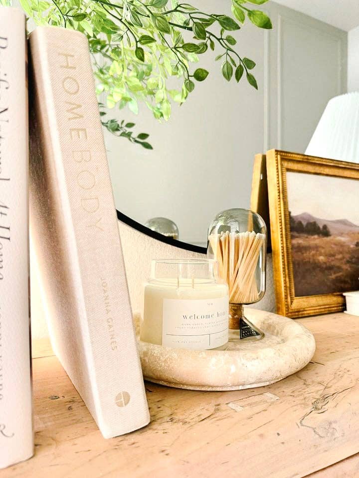 Welcome Home soy candle by Forget Me Not Candle Co. styled in a cozy home setting
