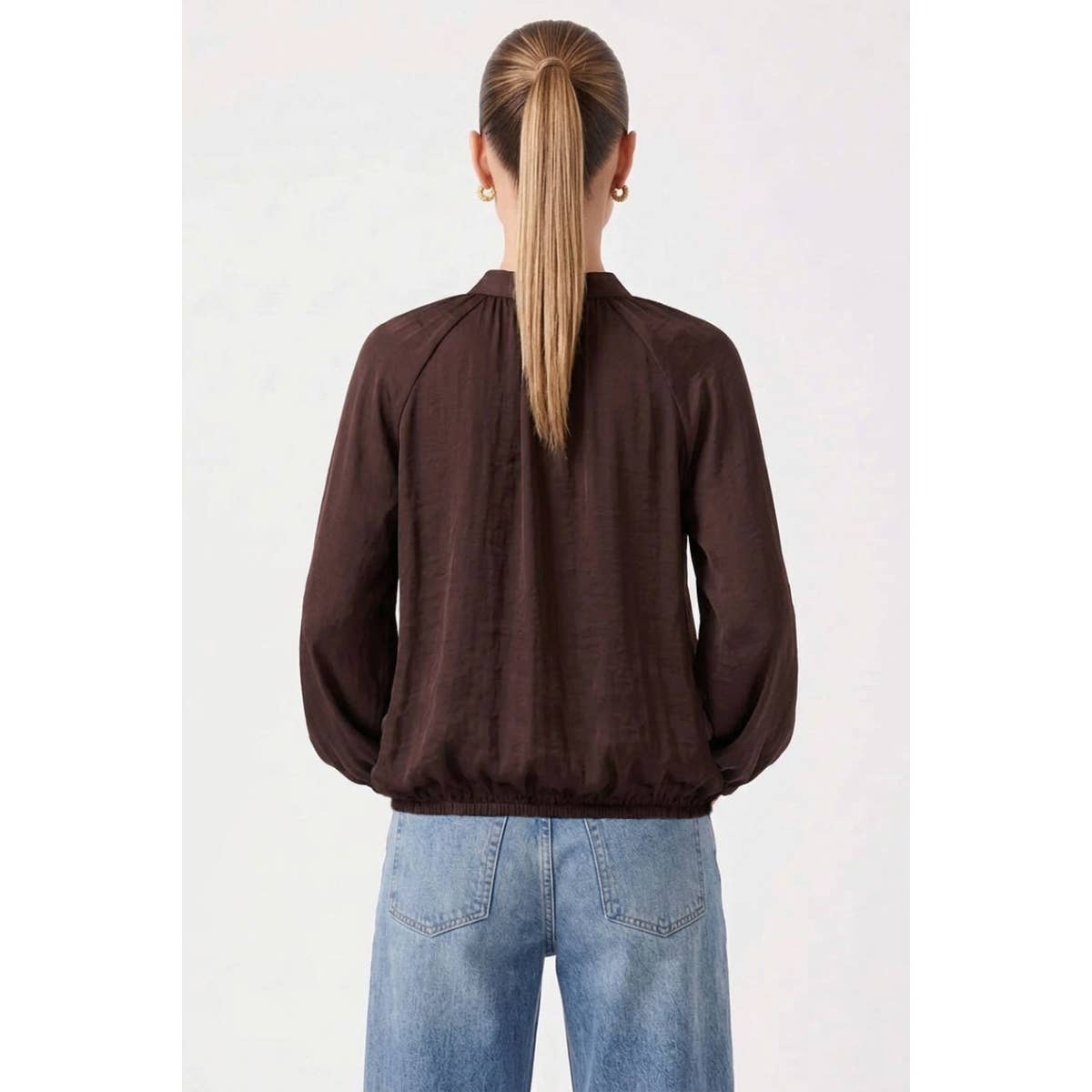 Back view of a Naked Zebra - Billowy Tie Neck Long Sleeve Blouse: Wine / L, featuring a dark brown tie neck with a cinched waist, worn with blue jeans.