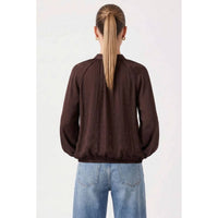 Back view of a dark brown Naked Zebra - Billowy Tie Neck Long Sleeve Blouse: Chocolate / L with long sleeves and a cinched hem, worn with blue jeans.