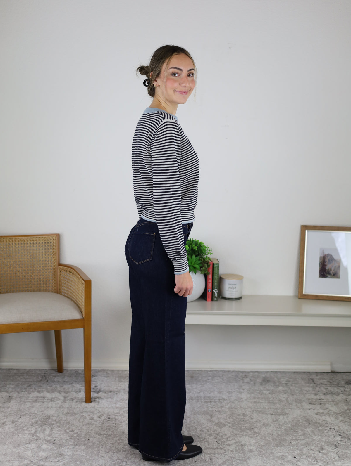 A woman wearing a Vera Striped Cardigan in navy and white with light blue trim and wide-leg dark wash jeans, perfect for fall layering.