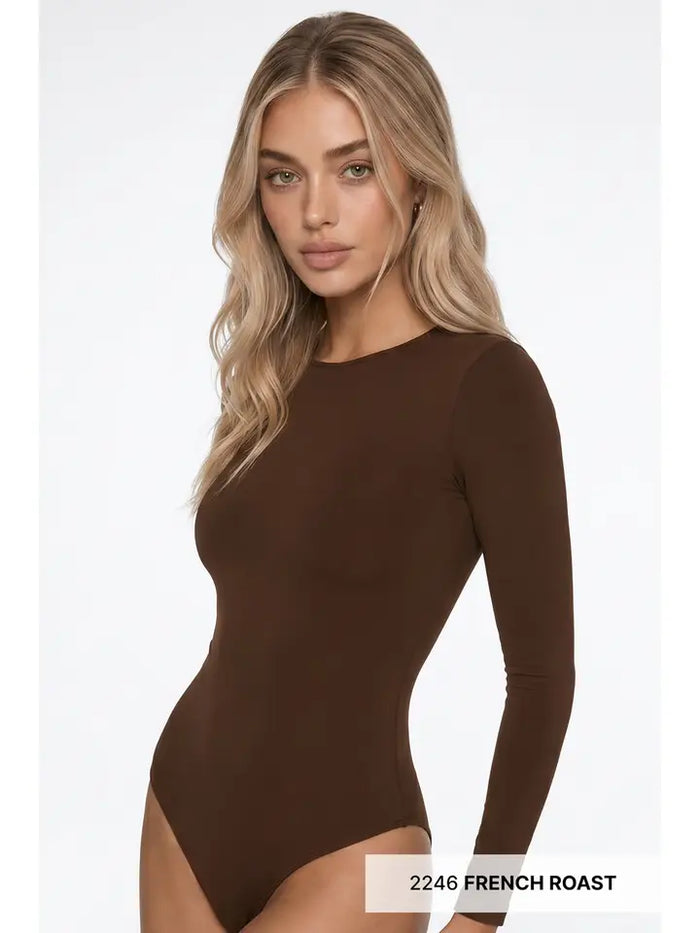 A woman with long blonde hair wears the High Neck LS Bodysuit, a fitted, long sleeve piece styled as the perfect layering option. She stands against a plain white background. Text at the bottom right reads 2246 FRENCH ROAST.