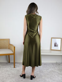 A person viewed from behind wearing a Desi Drape Neckline Maxi Dress in olive green with a draped neckline and black heeled sandals.