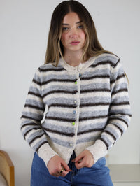 The Lark Lace Trim Striped Knit Cardigan with Candy Buttons is a cropped, striped knit cardigan in grey, white, and brown, featuring multicolored buttons and lace trim along the button placket.