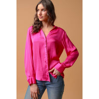 A person wearing a Naked Zebra - Neck Shirt With Open Seam Sleeve: Wine / L, a fuchsia, woven polyester button-down shirt with open seam details on the sleeves, and blue jeans.