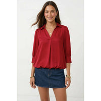A woman wearing a Naked Zebra - Half Sleeve Hi-lo Bubble Hem Blouse: Wine / L paired with a blue denim mini skirt.