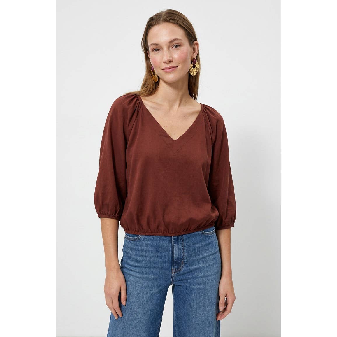 Naked Zebra - Elastic Puff Sleeve V-neck Blouse: Burgundy / L, a burgundy V-neck puff sleeve blouse with an elasticized waist, worn with blue jeans.
