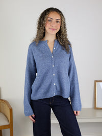 A person wearing a light blue Davis Lightweight Cardigan and dark blue jeans.