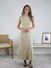 A woman wearing a sleeveless, beige suede Cole Suede A-Line Maxi Dress with visible seam detailing.