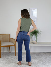 A person seen from behind, wearing a sleeveless green top and High Rise Tonal Crop Flare Denim jeans.