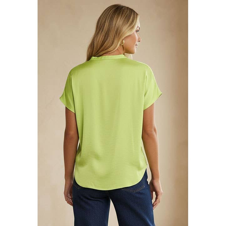 Woman seen from behind wearing a Naked Zebra - Drop Shoulder Regular Blouse: Chocolate / L in lime green and blue jeans.