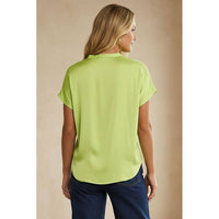 Woman seen from behind wearing a Naked Zebra - Drop Shoulder Regular Blouse: Chocolate / L in lime green and blue jeans.