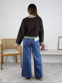 A person seen from behind wears a Maya Contrast Hem Cardigan in dark brown with light green trim at the neckline, cuffs, and hem, paired with wide-leg blue jeans.