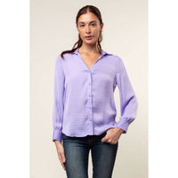 A woman wears a Naked Zebra - Neck Shirt With Open Seam Sleeve: Wine / L, a light purple woven polyester button-down shirt with a pointed collar and open seam sleeve detailing.