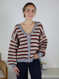 The Grayson Relaxed Stripe V-Neck Button Cardigan is a cozy, relaxed-fit sweater featuring horizontal stripes in red, cream, and grey with a button-front closure.