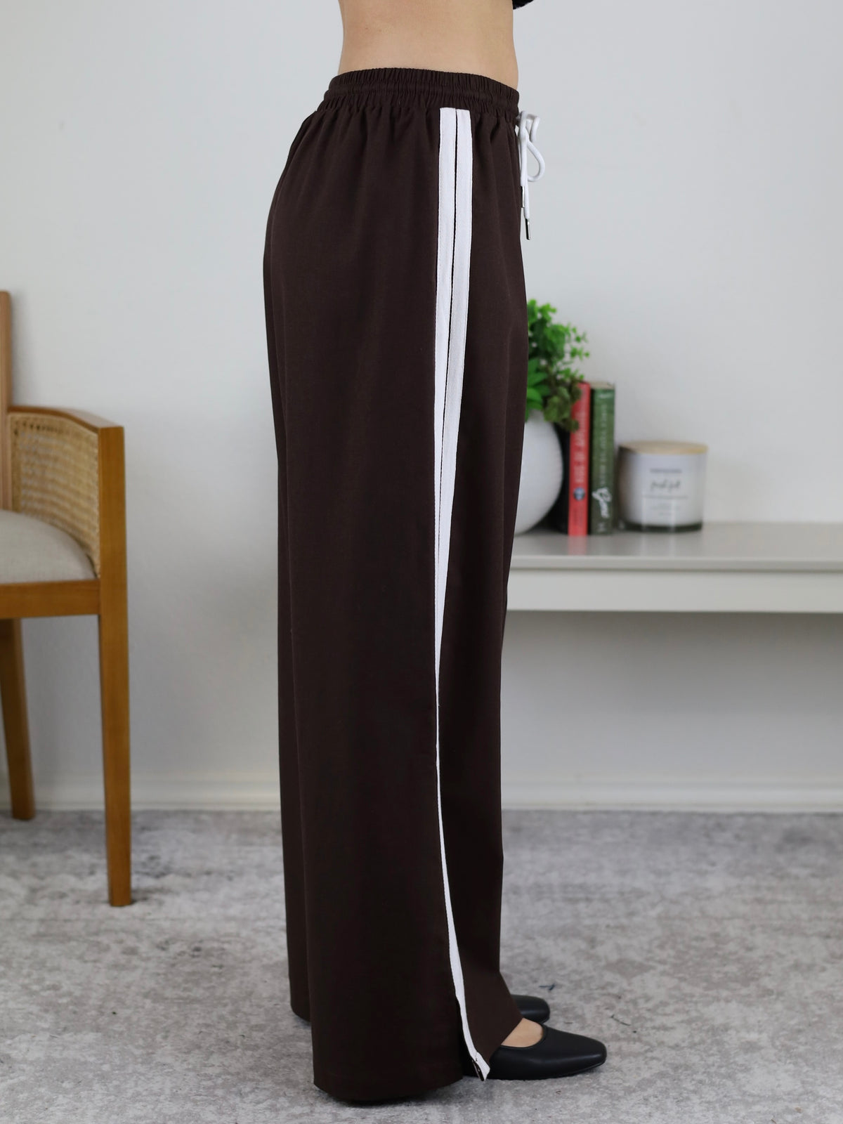 Profile view of Urban Wide Leg Side Stripe Linen Track Pant in dark brown with a white side stripe and a drawstring waist.