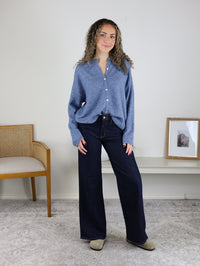 A woman wearing a soft knit Davis Lightweight Cardigan and wide-leg dark wash jeans.