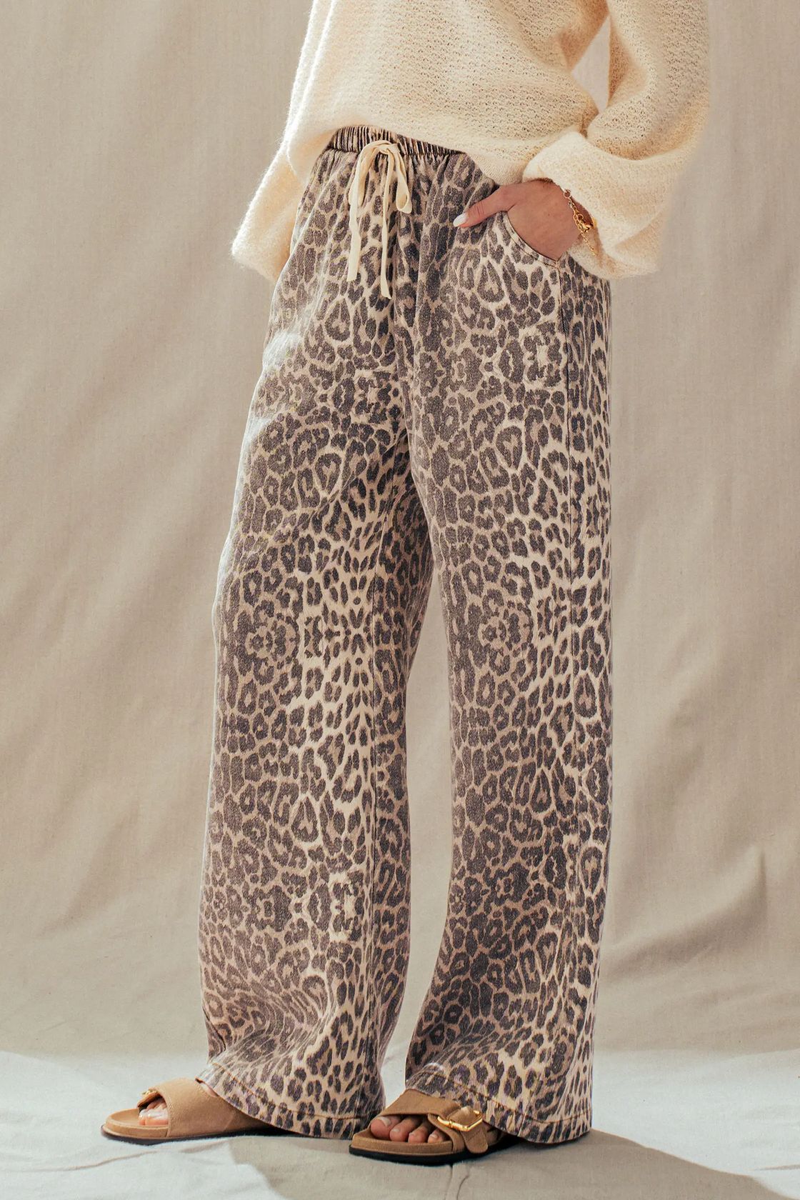 Rusty leopard print wide-leg pants styled with a cream knit sweater for a casual look