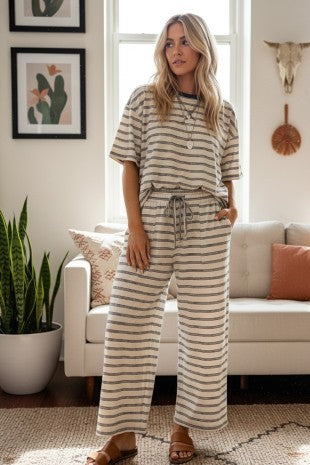 Woman wearing oversized striped knit pant set with wide-leg pants in oat and brown colorway