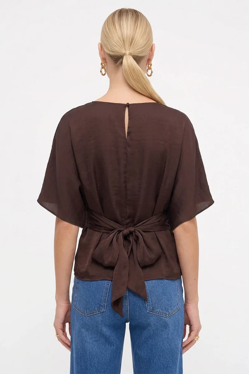Back view of the Louise Back Tie Dolman Sleeve Silky Blouse in brown, featuring a silky satin finish, an adjustable back tie at the waist, and a keyhole button closure at the nape.