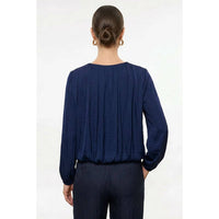 Back view of a person wearing a Naked Zebra - Long Sleeve Draped Bubble Hem Blouse: Wine / L, featuring a deep blue, long-sleeved draped design with a gathered bubble hem.