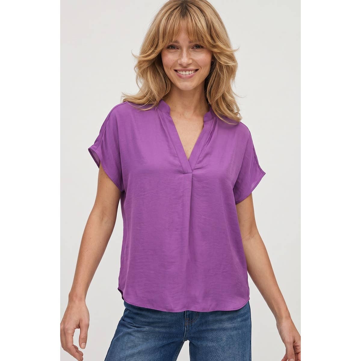 A woman wearing a purple, short-sleeved drop shoulder V-neck Naked Zebra - Drop Shoulder Regular Blouse: Chocolate / L.