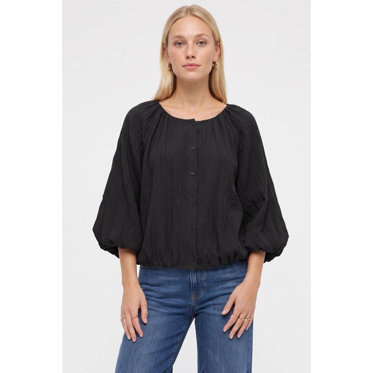 A woman wearing a Naked Zebra - Crinkle Texture Bubble Hem Button Up Blouse: Black / L, featuring three-quarter length balloon sleeves and a crinkle texture bubble hem.