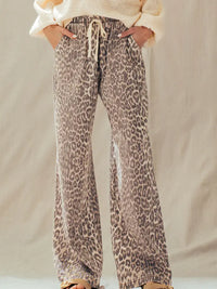 Woman wearing rust leopard print wide-leg cotton pants with a cream sweater, front view