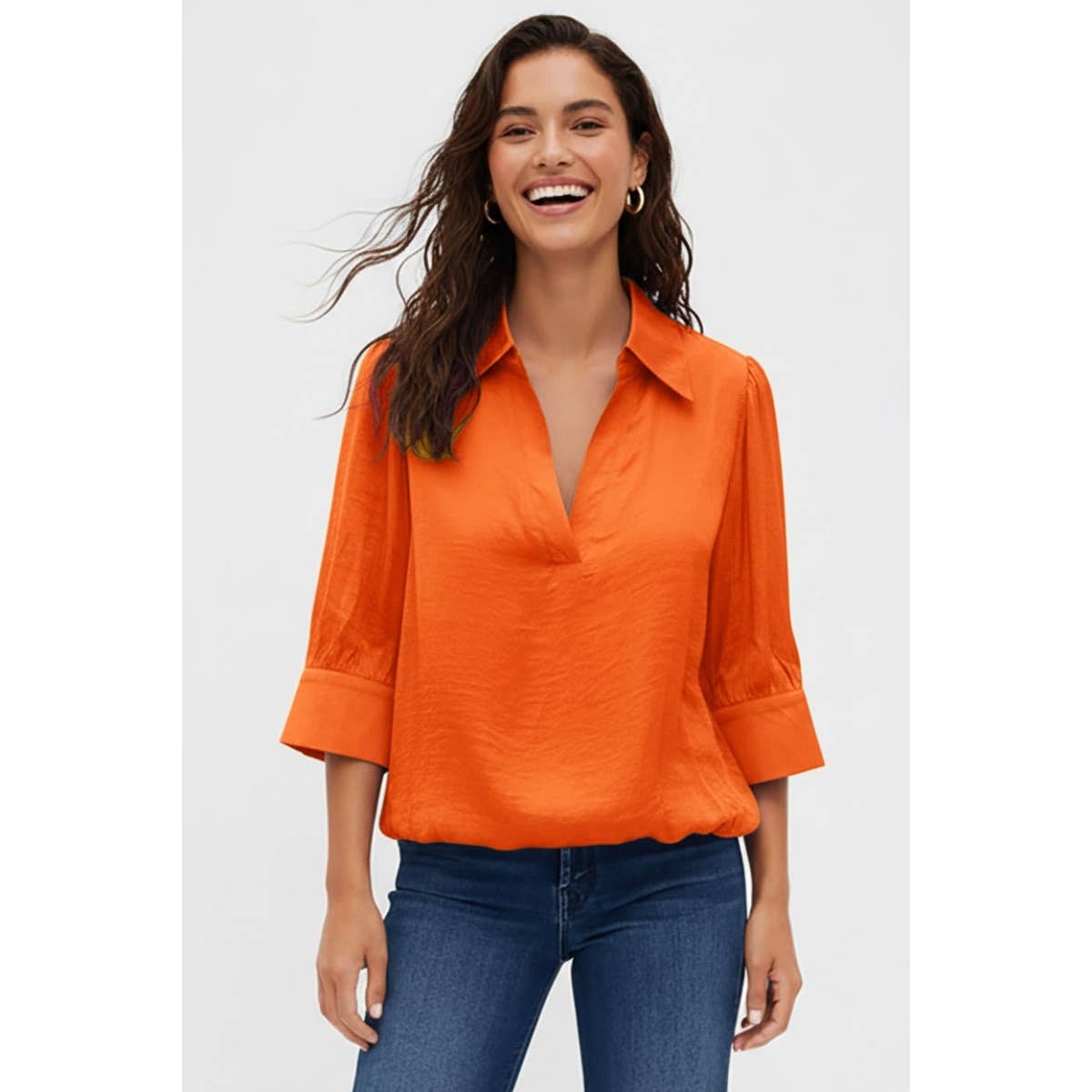 A woman smiling while wearing a Naked Zebra - Half Sleeve Hi-lo Bubble Hem Blouse: Wine / L, styled with a collared V-neck and blue jeans.