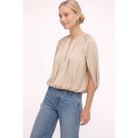 Naked Zebra - Silky Draped Cape Sleeve Blouse in wine, featuring a gathered neckline, keyhole cutout, and draped cape sleeves, worn with blue jeans.