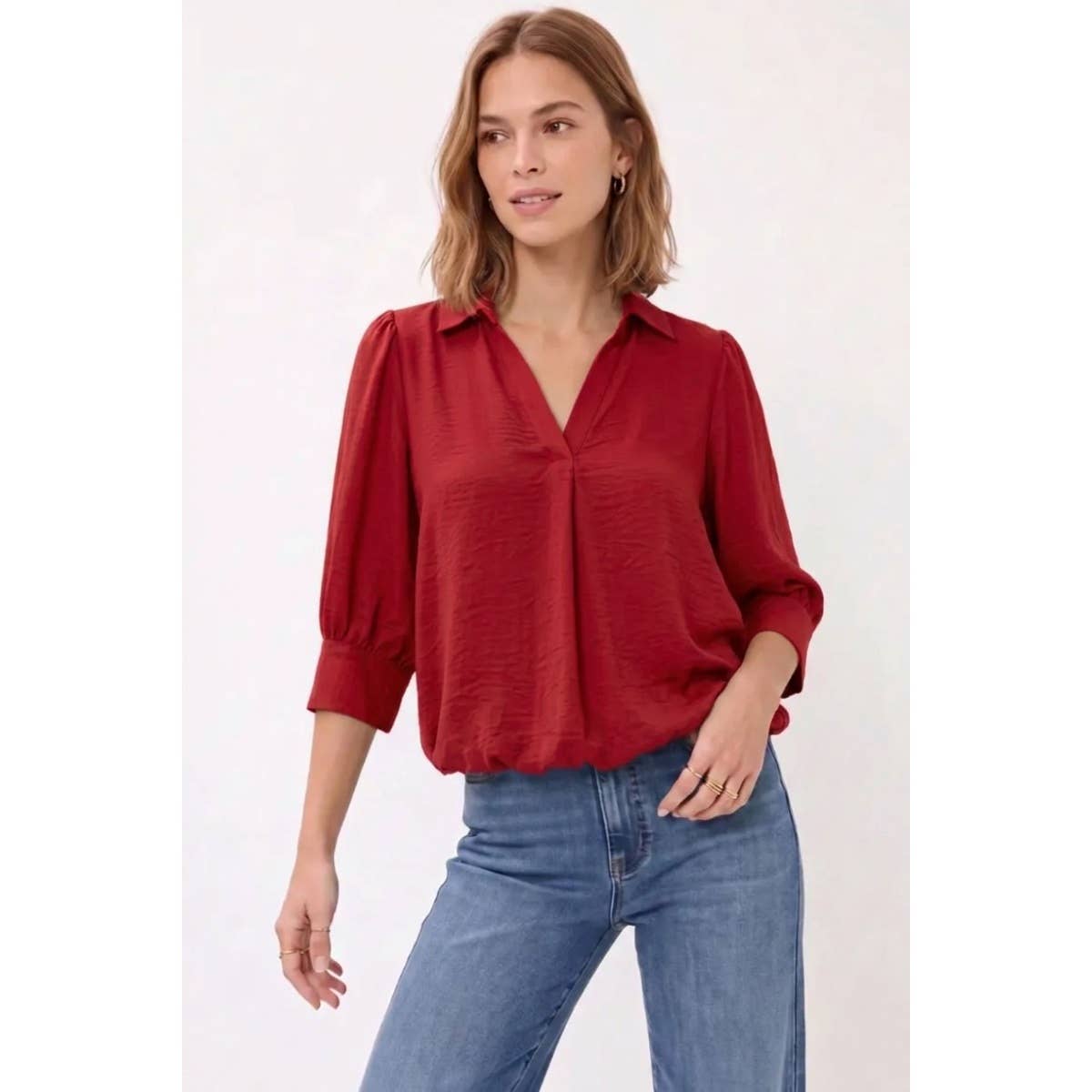 A wine-colored Naked Zebra - Half Sleeve Hi-lo Bubble Hem Blouse with a collared V-neck, worn with blue jeans.