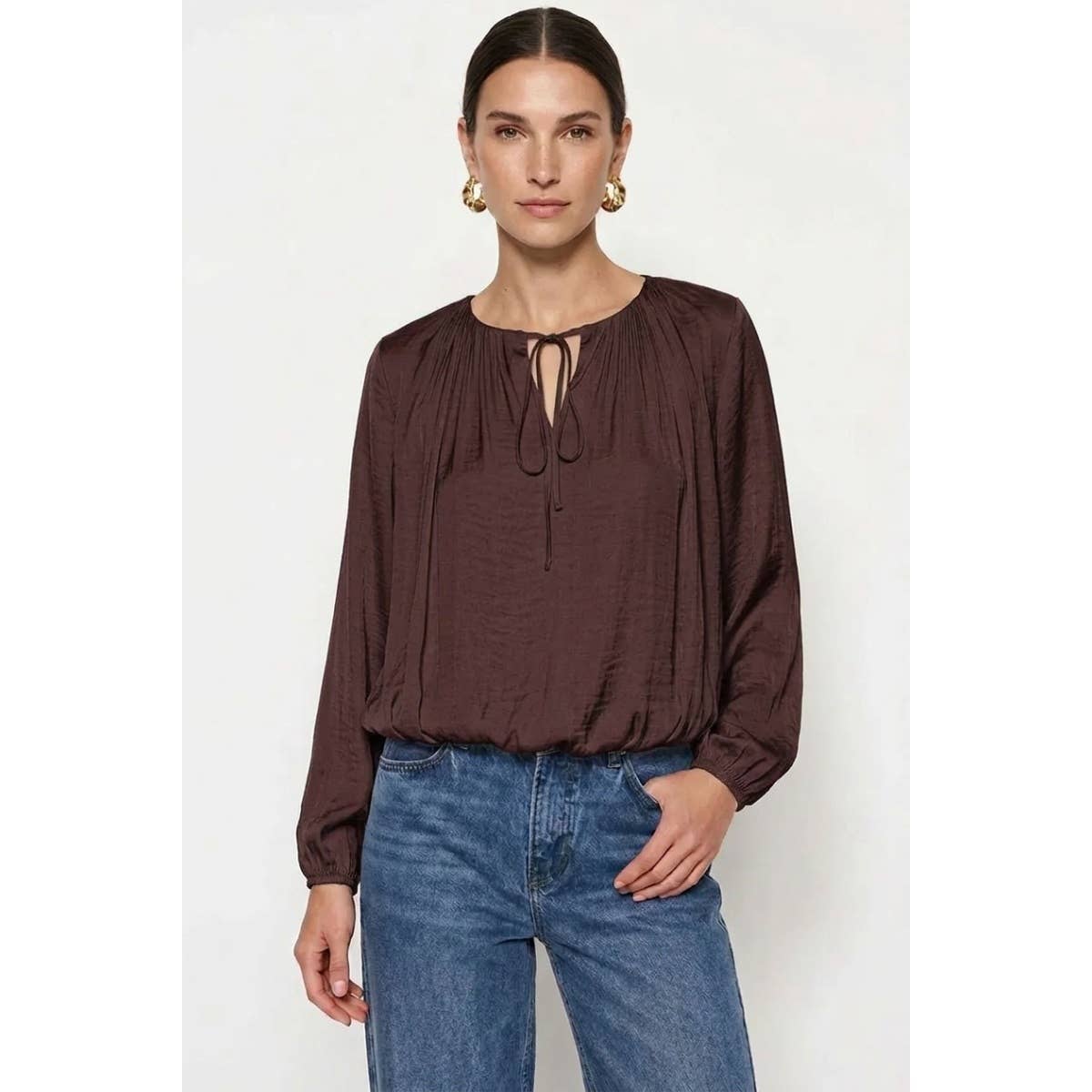 Naked Zebra - Long Sleeve Draped Bubble Hem Blouse: Wine / L, a long-sleeve, dark wine-colored satin blouse with a gathered neckline and tie detail, worn with blue jeans.