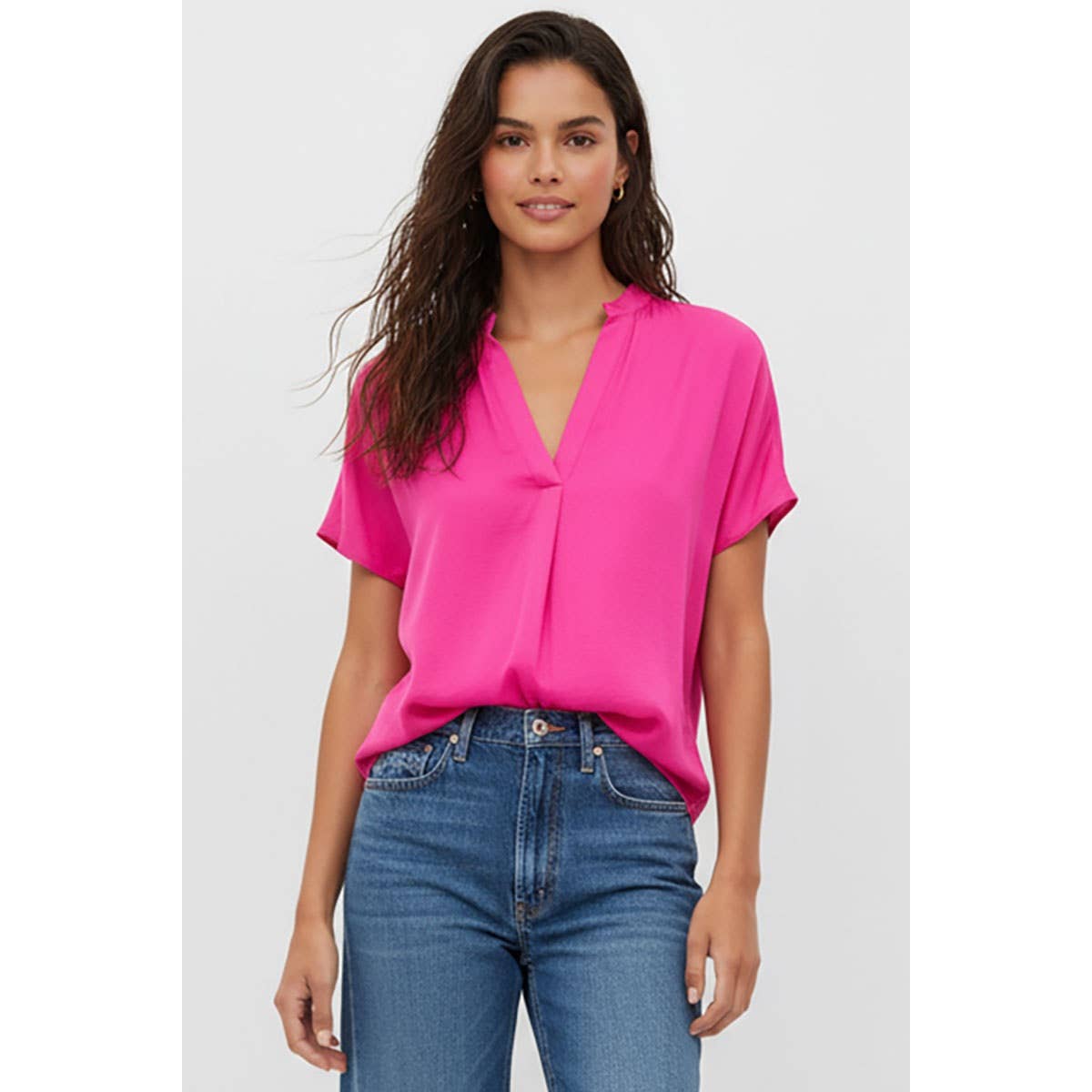Bright pink short-sleeve V-neck Naked Zebra - Drop Shoulder Regular Blouse worn with blue jeans.